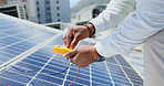 Technician, hands and multimeter testing solar panels for power or renewable energy inspection on rooftop in the city. Hand of contractor checking heated roof panel for electricity or quality test