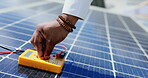 Technician, hands and multimeter testing solar panels for power or renewable energy inspection on rooftop in the city. Hand of contractor checking heated roof panel for electricity or quality test