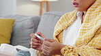 Woman, hands and thermometer checking fever, temperature or flu on living room sofa at home. Hand of sick female patient holding measuring tool for temp reading, healthcare testing or ill symptoms