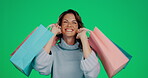 Woman, shopping bags and smile for fashion, discount or sale against a green studio background. Portrait of happy female shopper smiling in joyful happiness for stylish clothing gifts on mockup