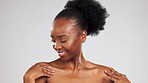 Body care, wellness and black woman touching her skin to feel soft, moisturised and smooth texture. Happy, health and African female model with a glowing self care treatment by gray studio background