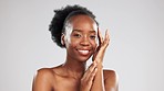 Beauty, portrait and black woman with a glow from skincare isolated on grey studio background. Cosmetic, smile and African girl touching her face for a soft, feminine and clear complexion and mockup