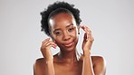 Glow, portrait and black woman feeling her face isolated on grey studio background. Cosmetic, smile and African girl touching facial skin for a soft, feminine and clear complexion and mockup