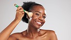 Makeup, face and happy black woman with brush in studio isolated on a gray background. Skincare smile, cosmetics or laughing female model with product or tool to apply foundation or powder for beauty