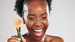 Face, makeup and laughing black woman with brush in studio isolated on a gray background. Skincare, cosmetics and portrait of funny female model with tool to apply foundation or powder for beauty.