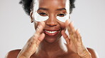 Face, skincare and happy black woman with eye mask in studio isolated on a gray background. Dermatology portrait, beauty cosmetics and female model pose with facial collagen patches for healthy skin.