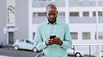 Black man, typing on phone and street in city for communication, social media and 5g network. Business person outdoor with smartphone connection writing email or online chat during urban travel