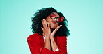 Face, heart glasses and blow a kiss with a black woman in studio on a blue background for valentines day. Fashion, love and vogue with an attractive young female wearing emoji eyewear for romance