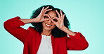 Face, fun and finger glasses with a black woman comic in studio on a blue background for humor. Portrait, funny and joking with an attractive or playful young female making a hand gesture indoor