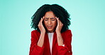 Stress, headache and anxiety with a black woman rubbing her head in pain in studio on a blue background. Mental health, burnout and migraine with an attractive young female messaging her temples 