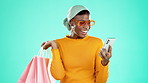 Bags, retail and black woman with smartphone, discount and social media against a blue studio background. African American female customer, lady and client with expensive clothes, cellphone and smile