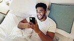 Happy man, phone and lying on bed above in social media, chatting or texting in relax and smile at home. Top view of male smiling on smartphone in bedroom browsing or enjoying streaming entertainment