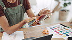 Woman, hands and color swatches in small business for fashion, interior or design in creative startup at office desk. Hand of female designer looking at colors or palette in clothing for choice