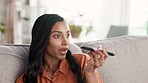 Woman, phone call and speaker on living room sofa for conversation, discussion or voice note at home. Female talking on smartphone in recording, networking or speaking about social life on couch