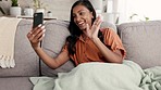 Woman, phone and video call waving on living room sofa for conversation, discussion or greeting at home. Happy female talking on mobile smartphone app in virtual chat networking or speaking on couch