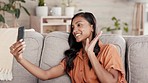 Woman, phone and video call waving on living room sofa for conversation, discussion or greeting at home. Happy female talking on mobile smartphone app in virtual chat networking or speaking on couch