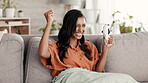 Woman, gaming and celebration for winning, victory or achievement relaxing on living room sofa at home. Happy and excited female gamer celebrating win or promotion with controller on console game