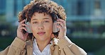 Portrait, music and woman remove headphones outdoors in a city or urban town while travel listening to a podcast. Audio, radio and young African American female finish song with smile and happy