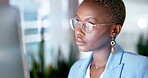 Serious black woman, glasses and business on computer in night, online research and planning strategy. Young female worker, evening and desktop technology for overtime, reflection and administration