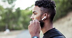 Fitness, runner and music with a sports man listening to audio while outdoor for a cardio or endurance workout. Exercise, running and earphones with a male athlete streaming the radio while training