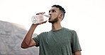 Mexican man, drinking water after running in city with mountain, hydration and outdoor with fitness. Thirsty after run, athlete and cardio with health, h2o with wellness, exercise and healthy life