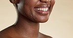 Closeup, black woman and oral health with smile, wellness and hygiene against studio background. Zoom, African American female or lady with cosmetics, funny and laughing with happiness or clean mouth