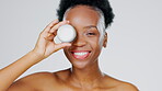 Face, lotion and beauty with a model black woman in studio on a gray background for skincare treatment. Portrait, playful or product with an attractive young female indoor to apply facial moisturizer