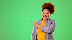 Happy woman pointing to green screen isolated on studio background for product placement, mockup or promotion. Young person or excited model face showing mock up chromakey space for gen z information