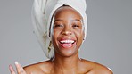 Black woman, face and cream, fun and laughing, beauty portrait and moisturizer dot on nose isolated on studio background. Happy female, towel and skincare with lotion, cosmetic product and playful