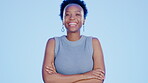 Portrait, laughing a black woman arms crossed on a blue background while standing in studio. Face, motivation and funny with an attractive female feeling positive or confident on a color wall