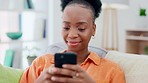 Cellphone, communication and black woman on a sofa typing a text message while relaxing in her living room. Technology, chat and African female networking on social media or mobile app with a phone.