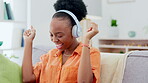 Black woman dancing on couch with headphones, music streaming and mental health, wellness and happy energy. African person dance on sofa, listening to audio technology and singing hip hop audio