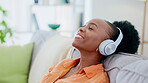 Relax, headphones and black woman on couch for music streaming, mental health and home wellness. Young person in lounge or sofa listening to calm, zen or happy radio on audio technology or internet