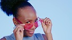 Black woman, sunglasses and face in studio with wink, choice or happiness for fashion by blue background. Gen z girl, heart glasses or shades with choice, portrait or happy for accessory by backdrop