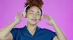 Dance, music and happy black woman with headphones in studio for relaxing, chilling and happiness. Fashion, dancing and face of girl on purple background listening to track, streaming audio and radio