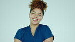 Portrait, smile and arms crossed with a woman in studio on a gray background looking relaxed or positive. Face, happy and carefree with an attractive young female against a pastel color wall