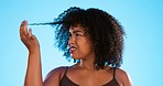 Afro, hair damage and confused black woman on blue background with problem, hairstyle frizz and loss. Beauty salon, hairdresser and frustrated girl with strand for treatment, grooming or cosmetics