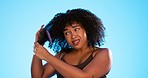 Frustrated, knot and black woman with comb for hair on blue background with problem, hairstyle frizz and damage. Beauty salon, hairdresser and sad girl brush afro for wellness, grooming and cosmetics