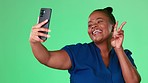 Selfie of black woman isolated on studio background or green screen with social media kiss, peace sign and emoji. Face of happy model or person in profile picture update or influencer lifestyle post