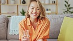 Happy woman, face and drinking glass of water in home, living room and lounge for healthy lifestyle, wellness and diet. Portrait, smile and asian female drink for hydration, detox nutrition and care 