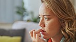 Anxiety, biting nails and woman with worry, thinking and nervous on sofa in living room with stress. Mental health, depression and face of girl worried, sad and confused with problem, issue and fail