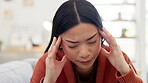 Headache, stress and burnout with an asian woman in the living room of her home suffering from pain. Mental health, anxiety or migraine with a young female holding her head while breathing in a house