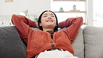 Asian woman, smile or relax on sofa in house, home or living room on weekend, day off or zen mental health. Happy, person or hands behind head on couch in peace, calm or self care mindset from break