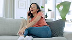 Phone call, gossip and a black woman on a sofa, sitting in the living room alone in her home to relax. Mobile, contact and conversation with an attractive young female chatting while in the house