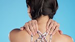 Rear view, sports and injury by woman with back pain in studio for ache, muscle or arthritis on blue background. Behind, spine and girl with injured neck, fibromyalgia or osteoarthritis problem 