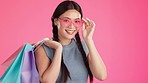 Shopping, studio and Asian woman portrait feeling happy with clothing sales purchase and bags. Isolated, pink background and fashion with a young, female and gen z model with deal and sale bag