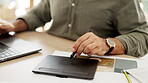 Hand, track pad and a business man using a stylus while working at a desk in his editing office. Creative, technology and art with a male editor or employee at work in a graphic design company