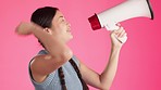 Woman, laughing or megaphone for news, announcement or protest for human rights, women empowerment or equality. Smile, happy or funny model and microphone, speaker or fist on isolated pink background