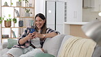 Phone, social media and a woman laughing on a sofa in the living room of her home while reading a meme. Mobile, text message and a happy female enjoying a funny joke or humor on the internet