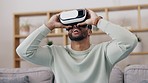 Vr, entertainment and man in the living room with a headset while playing a 3d video game. Futuristic, metaverse and male gamer sitting on sofa while gaming with virtual reality goggles in his home.